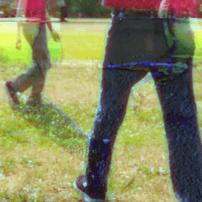 many people with pink shirts walking around a large grassy field.